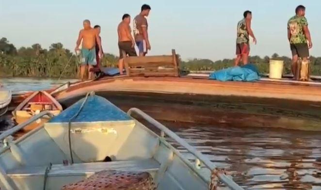 A imagem em destaque mostra várias pessoas em cima da embarcação que naufragou.